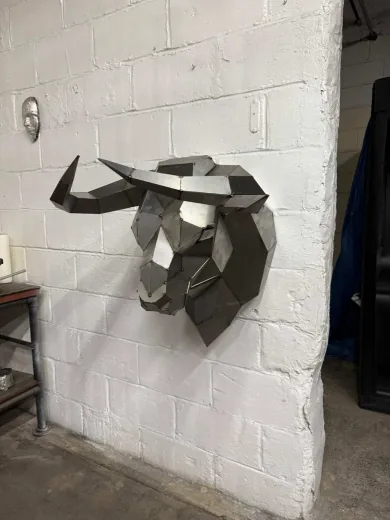 Customer-built low-poly steel Bull Head mounted on a white brick wall